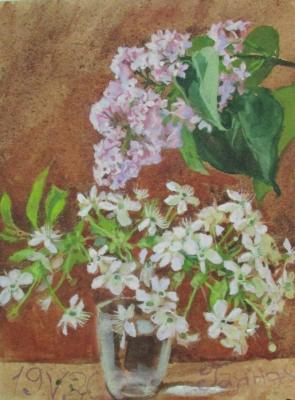 A bunch of lilacs and cherry flowers in a glass