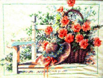 Carnations and a hat on a white bench on a bright sunny day