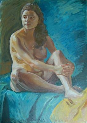 Naked girl sitting near the blue background