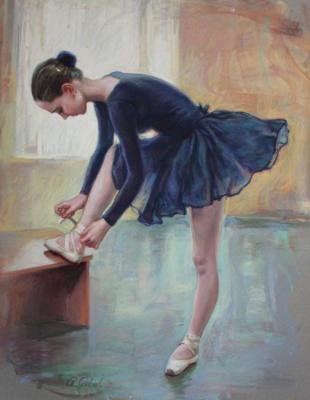Young ballerina adjusting her pointes